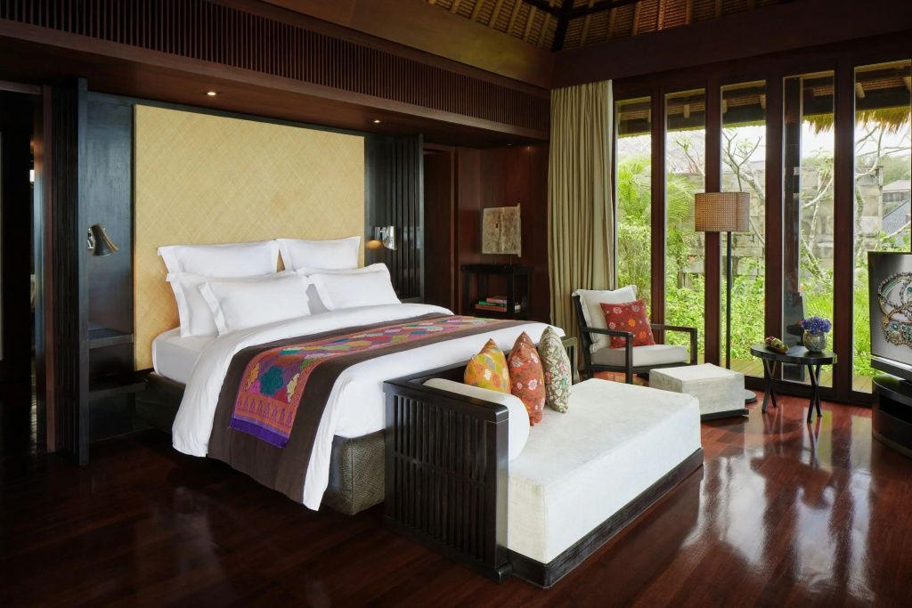 Elegant eingerichtetes Schlafzimmer der Bvlgari Villa mit Kingsize Bett und edlen Holzdetails.