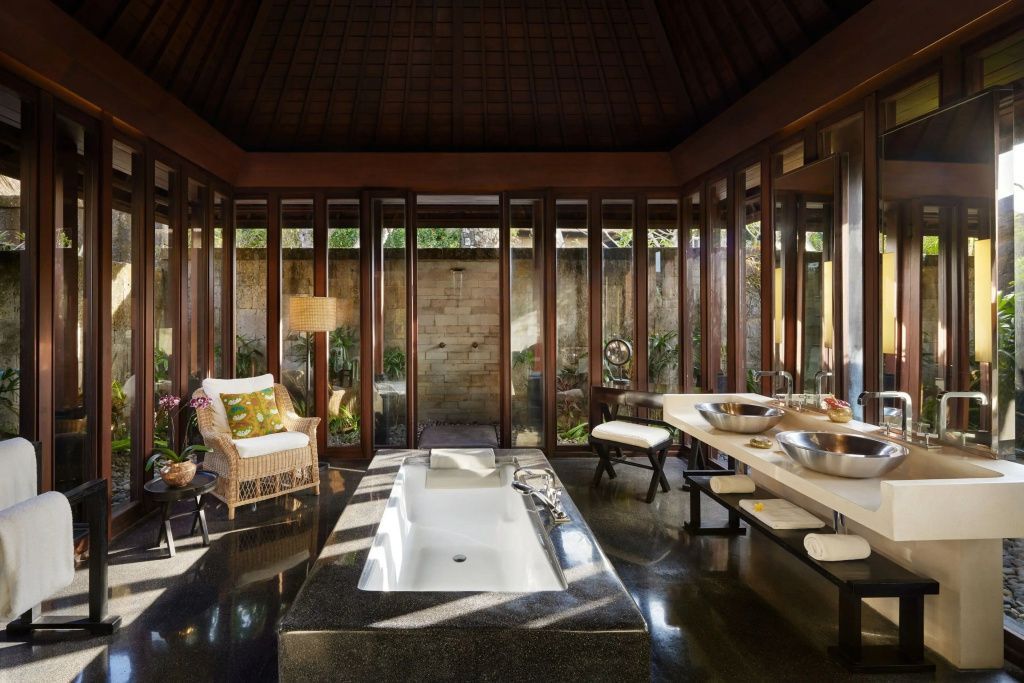 Luxuriöses Badezimmer der Villa mit versenkter Badewanne und Blick ins Grüne