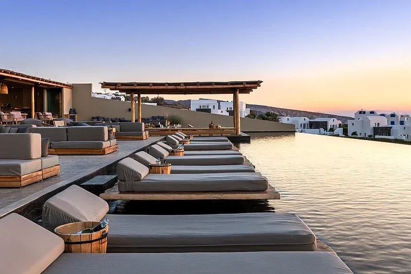 Infinity-Pool des Andronis Arcadia in Oia auf Santorini mit Liegen und Lounge bei Sonnenuntergang