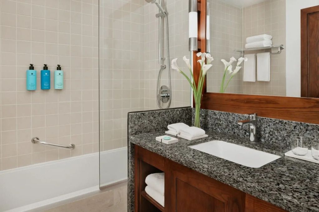 Modernes Badezimmer mit Granit-Arbeitsplatte und weißen Fliesen.