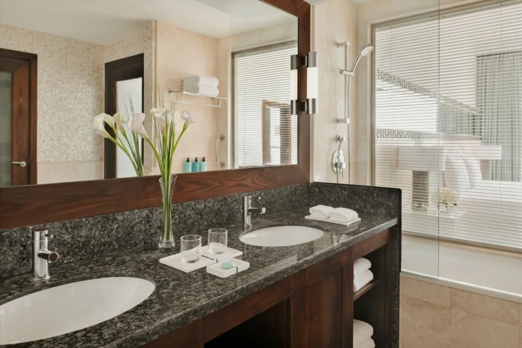 Modernes Badezimmer mit Doppelwaschbecken und Granitoberfläche.