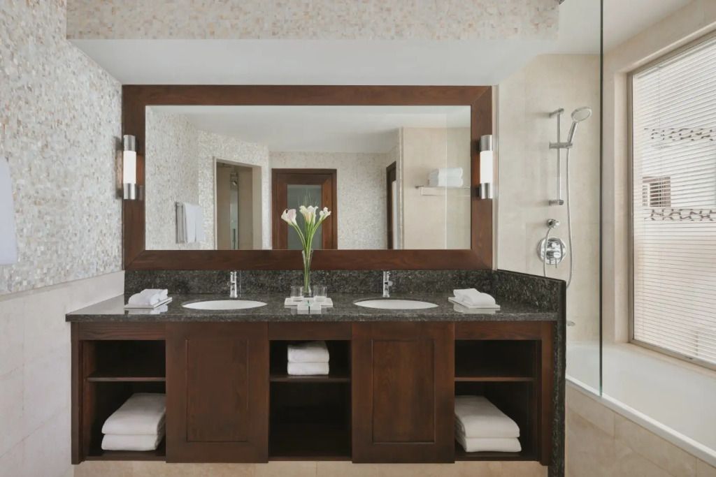 Geräumiges Badezimmer mit großer Spiegelfront und eleganter Dusche.