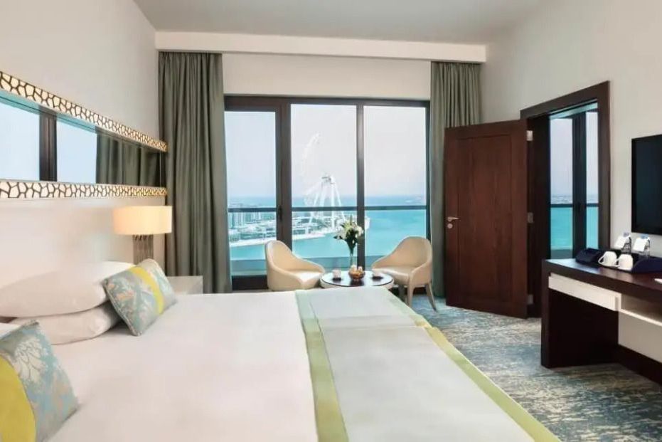 Familien Suite Schlafzimmer mit Meerblick durch Panorama-Fenster im Jumeirah Beach Hotel