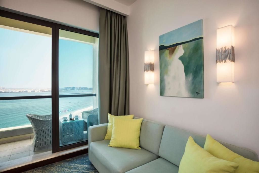 Gemütliche Sitzecke im Hotelzimmer mit Blick auf den Balkon