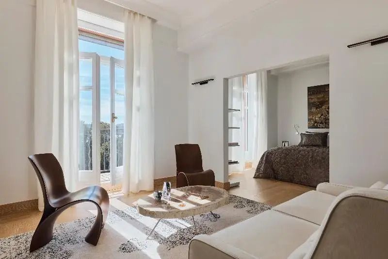 Helle Junior-Suite mit großem Fenster und stilvollen Möbeln im Hotel Le Beauvallon.