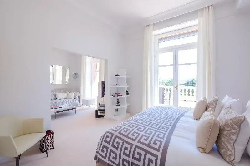 Helle Junior-Suite mit Balkon, komfortablem Bett und elegantem Dekor.