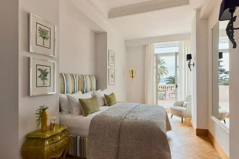 Helles Schlafzimmer mit Doppelbett und direktem Zugang zur Terrasse im Hotel Le Beauvallon