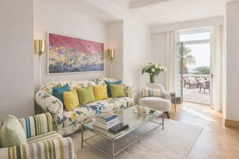 Wohnzimmer mit farbenfrohem Sofa und Zugang zur Terrasse im Hotel Le Beauvallon