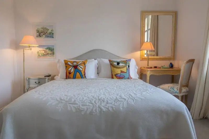 Hotelzimmer mit dekorativen Kissen auf weißem Doppelbett und sanfter Beleuchtung