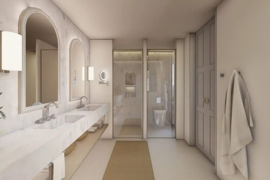 Modernes Badezimmer aus Marmor mit Doppelwaschbecken, beleuchteten Rundspiegeln und begehbarer Dusche.