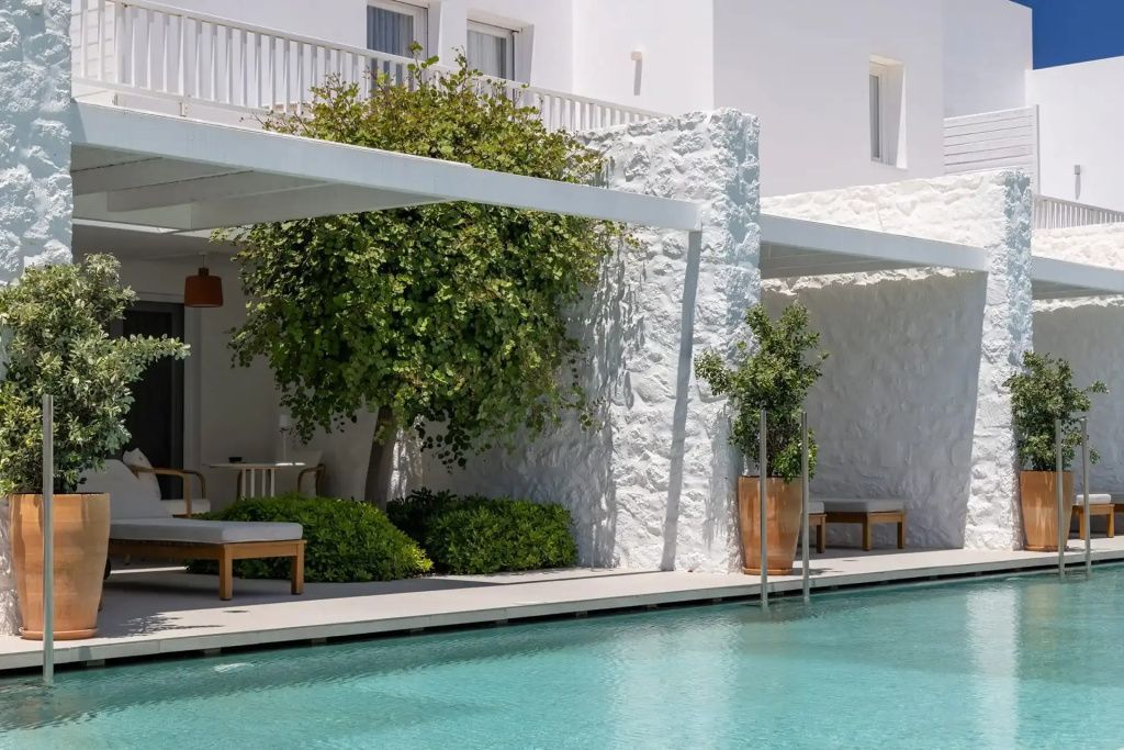 Private Poolterrasse mit Sonnenliegen und schattiger Pergola im Patmos Aktis Resort