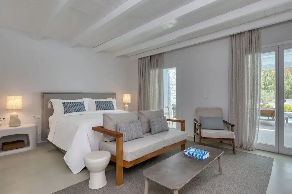 Doppel Junior Suite mit komfortablem Doppelbett, gemütlicher Sitzecke und hellen Deckenbalken