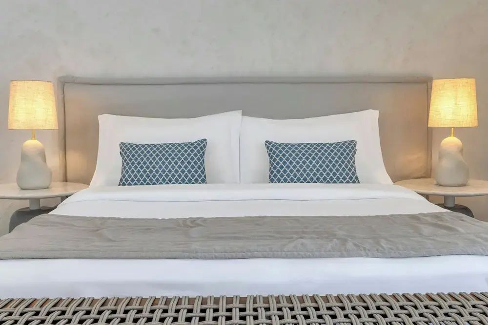 Eleganter Doppelbettbereich im Grand Doppelzimmer mit stilvollen blauen Kissen im Patmos Aktis Resort.