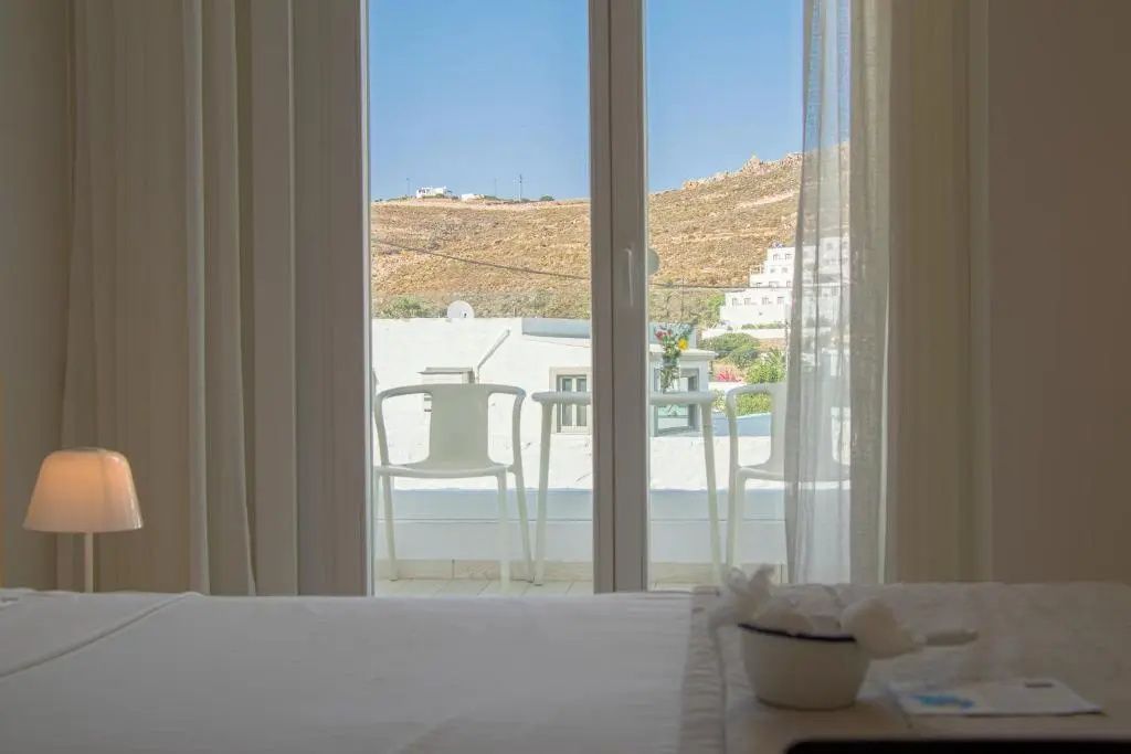 Blick vom Zimmer auf den Balkon und die malerische Berglandschaft von Patmos.