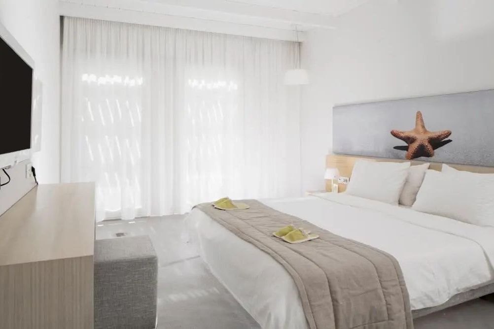 Helles Klassisches Zimmer mit Doppelbett und eleganter Einrichtung im Patmos Aktis Resort.