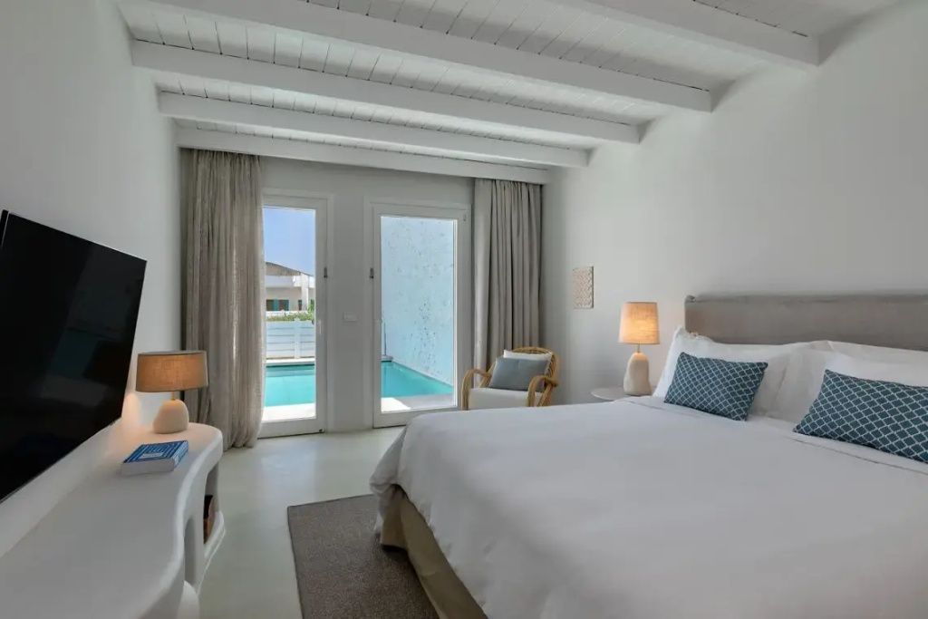 Helles Schlafzimmer der Suite mit Doppelbett und direktem Zugang zum privaten Pool.