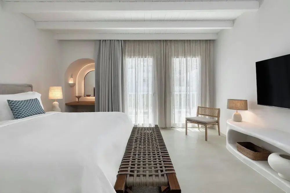 Elegant gestaltetes Schlafzimmer mit bequemer Sitzbank und modernem Nischenbereich.