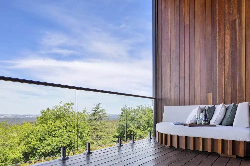 Holzverkleideter Balkon mit Sitzmöbeln und Blick auf die Natur