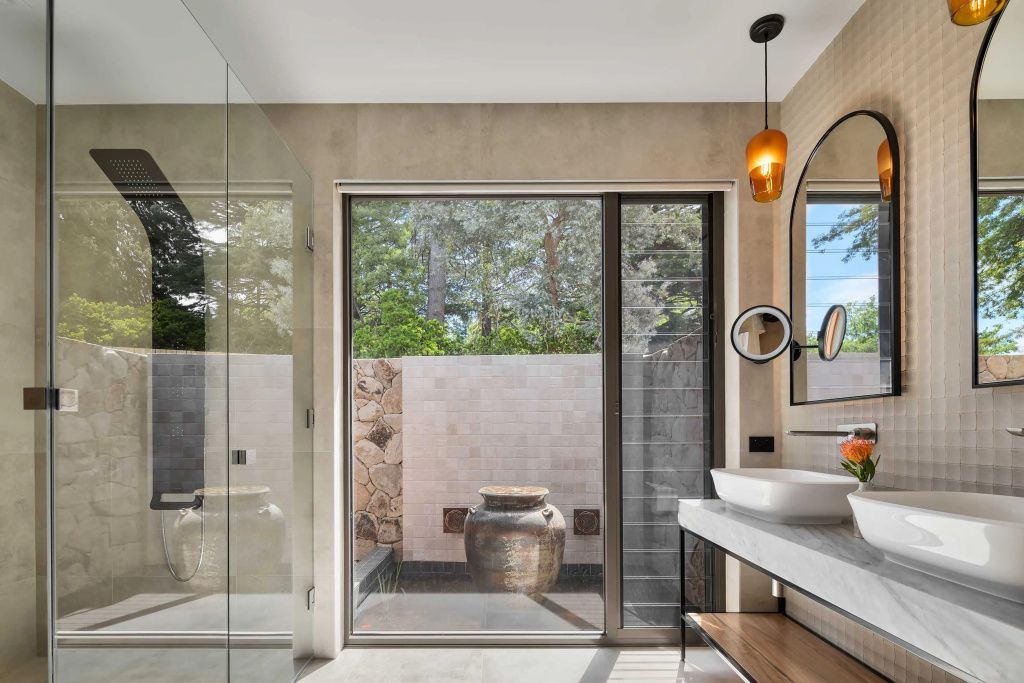 Badezimmer mit Blick auf Terrasse und grüne Umgebung in der Suite