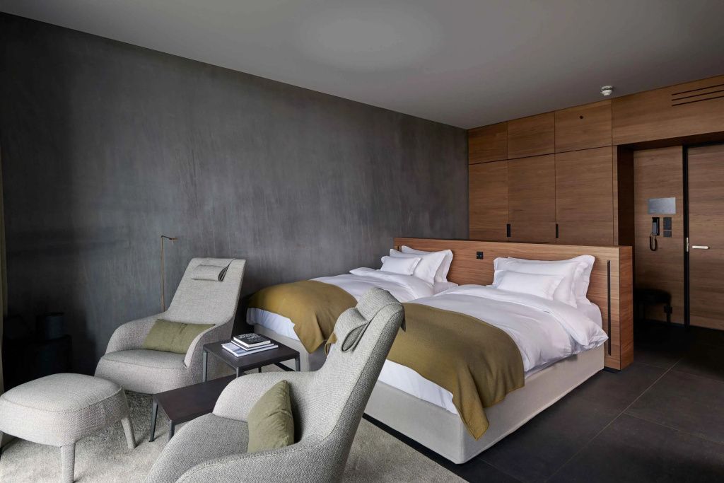 Lava Doppel Junior-Suite im The Retreat at Blue Lagoon mit zwei Einzelbetten und stilvollen Sesseln