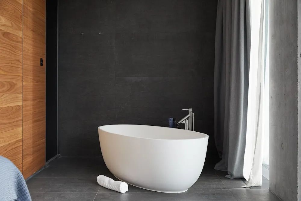 Freistehende Badewanne im eleganten Badezimmer der Lava Junior-Suite im The Retreat at Blue Lagoon