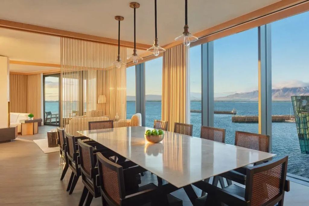 Großer Esstisch in der Penthouse Suite mit Stühlen und Panoramablick auf den Ozean.