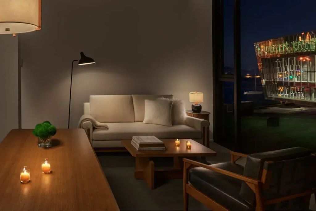 Elegant eingerichteter Wohnbereich der Suite mit beige Couch, Holztisch und warmem Licht.