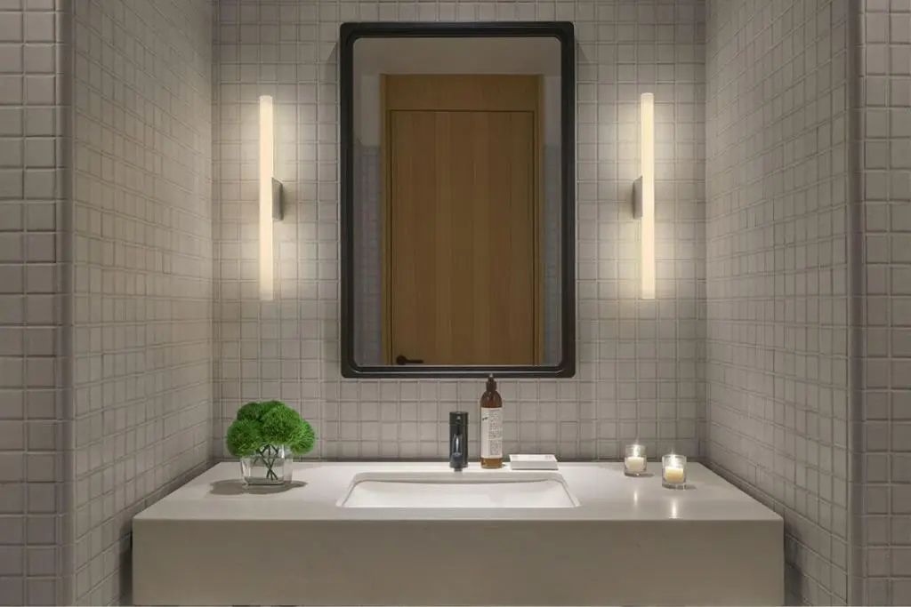 Stilvoller Waschtisch im Badezimmer mit eleganter Beleuchtung und einem Spiegel.