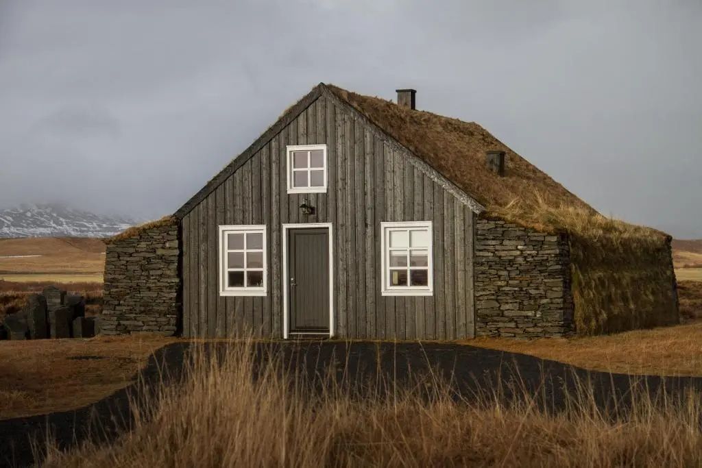 Traditionelles isländisches Torfhaus mit Holzfassade und Grasdach im Torfhús Retreat