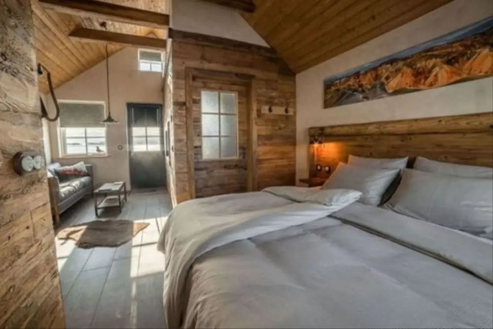 Schlafbereich der Suite mit komfortablem Doppelbett und stilvoller Holzverkleidung.
