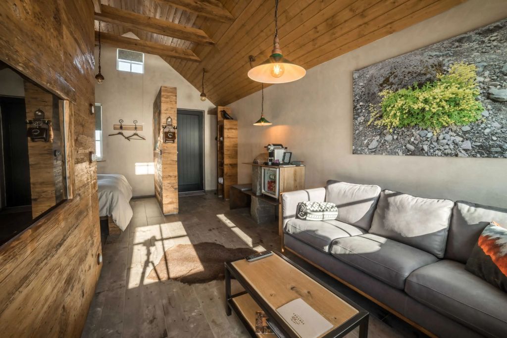 Gemütlicher Wohnbereich der Villa mit Holzverkleidung, bequemem Sofa und warmem Licht.