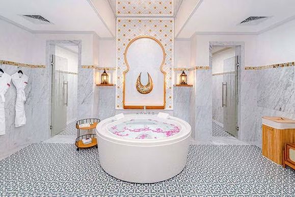 Badezimmer mit Rundbadewanne und aufwendiger Wanddekoration