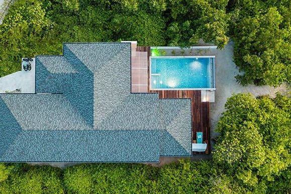 Vogelperspektive auf Villa mit privatem Pool umgeben von üppigem Grün
