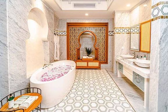 Luxuriöses Badezimmer mit Marmor und floraler Dekoration in der Wanne