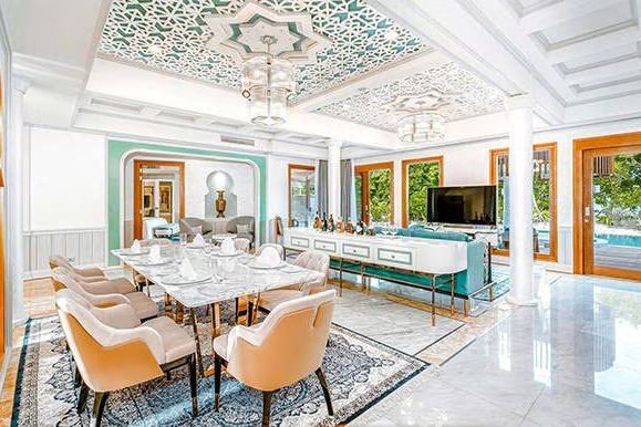 Stilvolles Wohnzimmer mit Essbereich und kunstvollen Decken