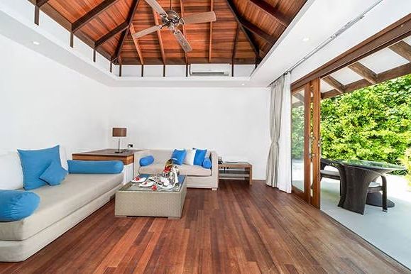 Wohnbereich mit hohen Decken, modernen Möbeln und Zugang zur Terrasse