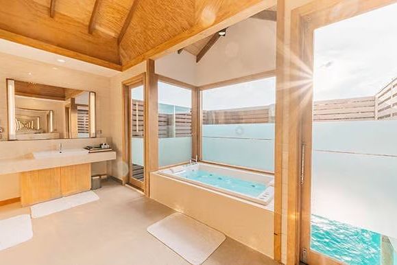 Helles Badezimmer mit Whirlpool und großzügigem Fenster