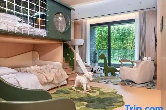 Spielzimmer der Familie Suite mit grünem Etagenbett, Holzschaukelpferd und Balkonzugang.