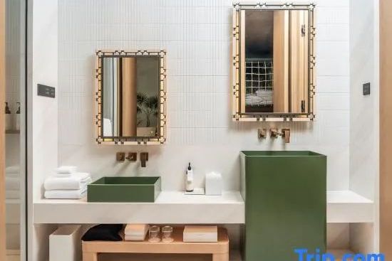 Luxuriöses Badezimmer mit grünen Waschtischen und zwei rechteckigen Wandspiegeln.