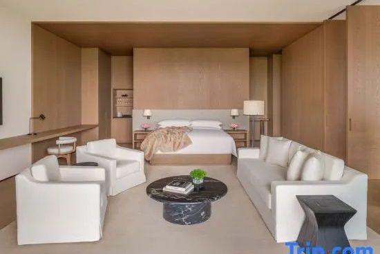 Großzügige Junior-Suite mit Kingsize-Bett, weißem Sofa und hellem Holzdesign.