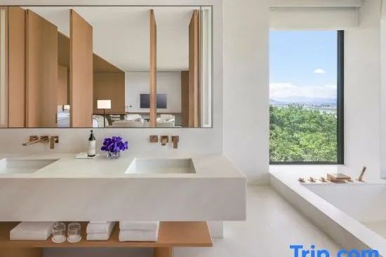 Luxuriöser Waschtisch im Badezimmer mit großem Fenster und Blick ins Grüne.
