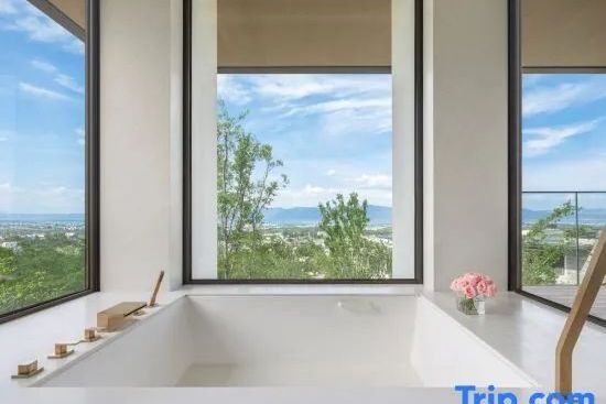 Tiefe Badewanne am Panoramafenster mit Weitblick auf die umliegende Natur.
