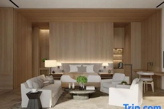 Großzügiger Schlafbereich der Präsidenten Suite mit eleganter Holzrückwand und bequemer Sitzgruppe
