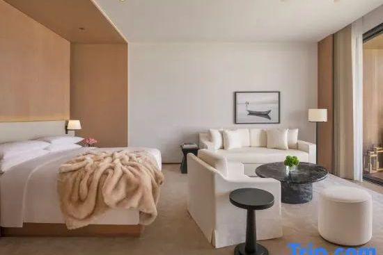 Gemütlicher Loungebereich und komfortables Doppelbett im Zimmer des The Dali EDITION