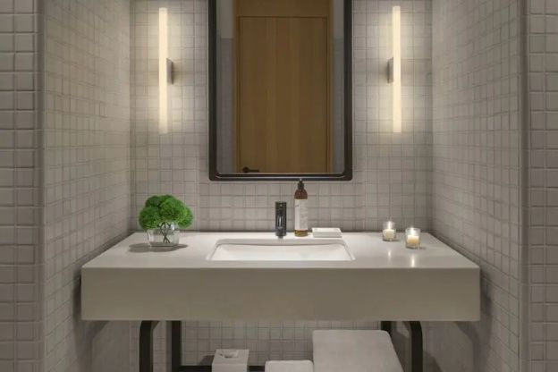 Modernes Badezimmer mit Waschtisch, frischen Handtüchern und stimmungsvollem Licht.