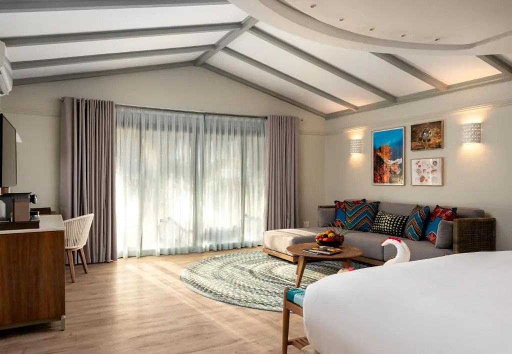 Geräumiges Zimmer mit großen Fenstern, moderner Dekoration und gemütlicher Sitzecke.