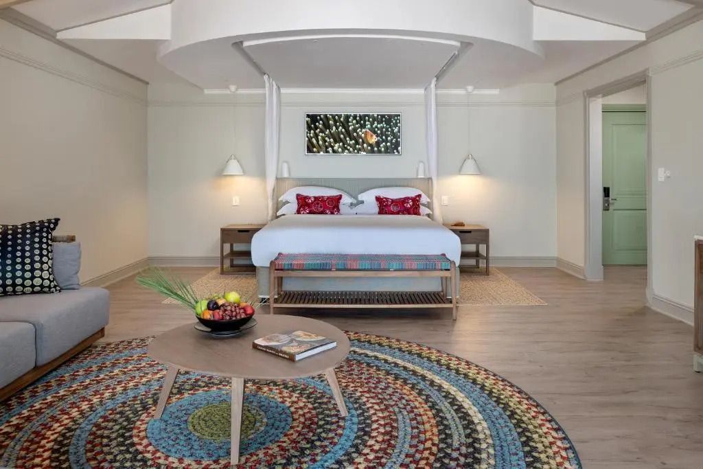 Zimmer mit Himmelbett, buntem Teppich und moderner Inneneinrichtung.
