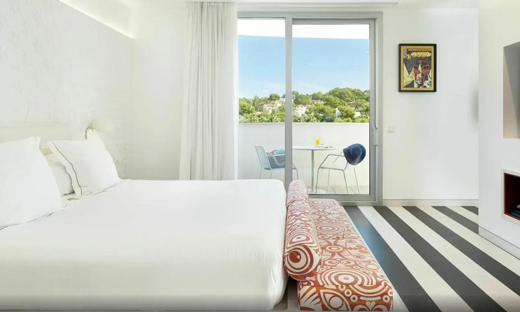 Helles Zimmer mit Doppelbett und Balkon mit Ausblick auf die Natur