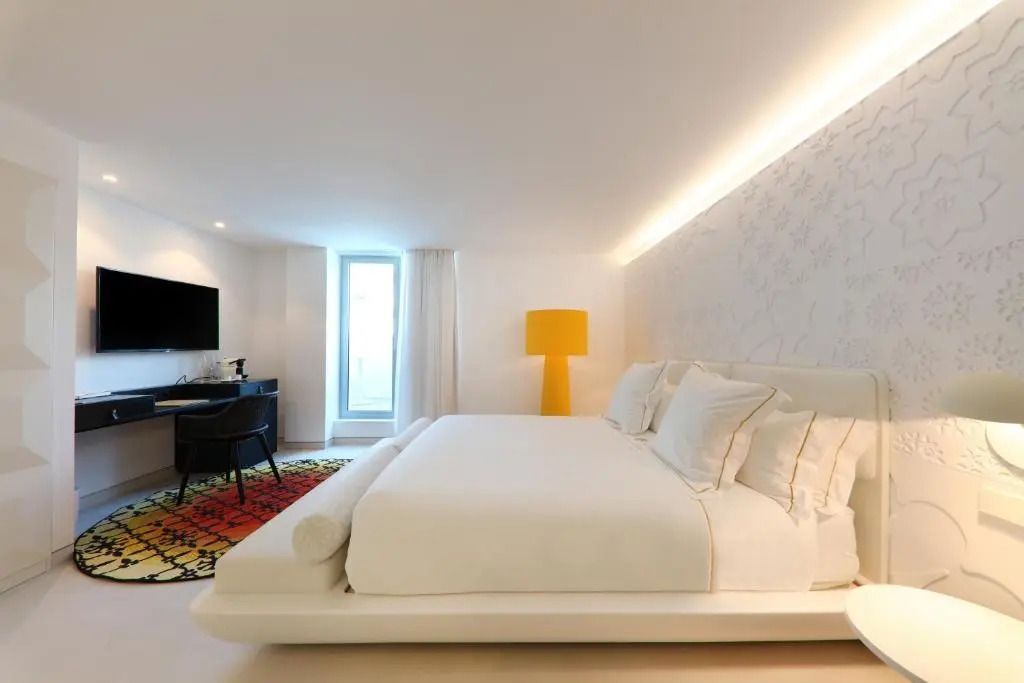 Helles Einzelzimmer mit weißem Dekor und gelber Lampe im Hotel 'The Donna Portals'
