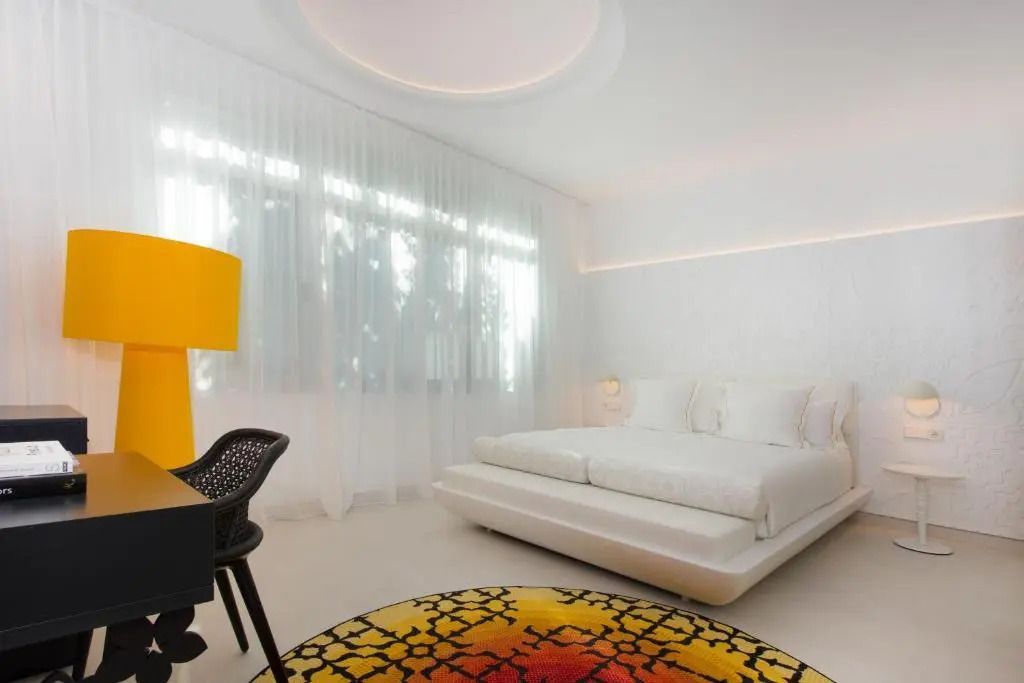 Modernes Zimmer mit gelben Akzenten und breitem Fenster im Hotel 'The Donna Portals'